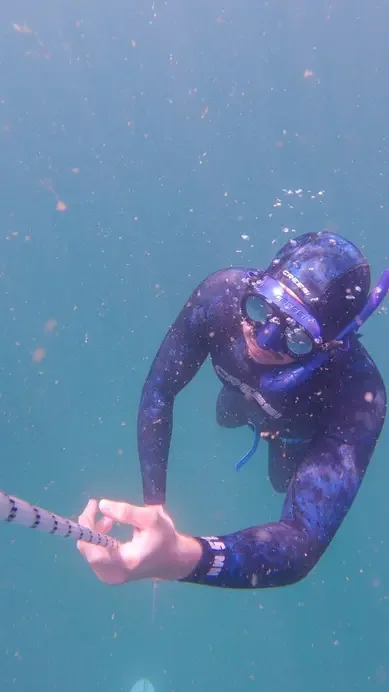 Snorkeller underwater holding a guide rope